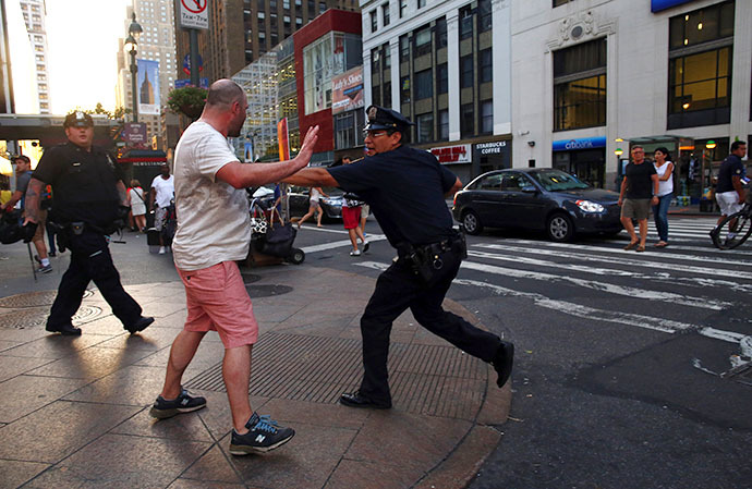 A police officer prevents a man from marching to Times Square during a rally in reaction to the acquittal of George Zimmerman in New York July 14, 2013.