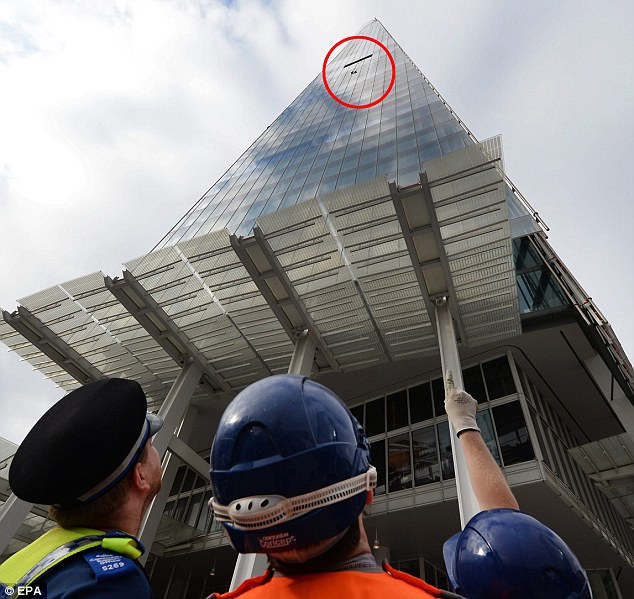 Statement of intent: A policeman and emergency services watch as six women activists climb The Shard