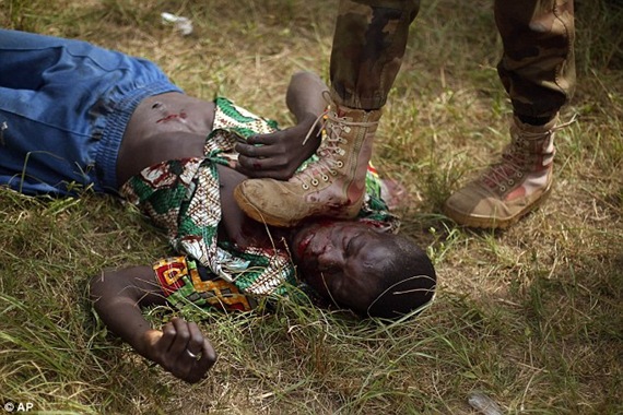 Newly enlisted FACA soldiers kick the face of a suspected Muslim Seleka militiaman moments after Central African Republic Interim President Catherine Samba-Panza addressed the troops in Bangui