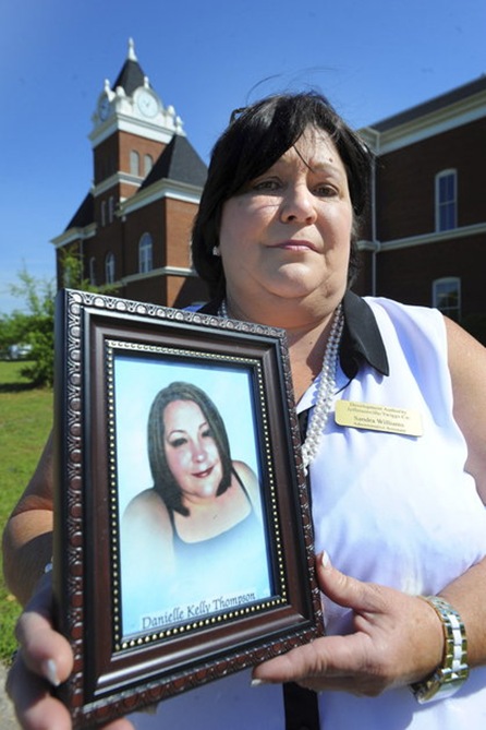 Sandy Williams holds a photo of her younger sister Danielle Kelly Thompson in May. Thompson’s husband of less than a month, Marcus D. Hoskins, 46, is accused of shooting her to death and dumping her body on a wooded trail.