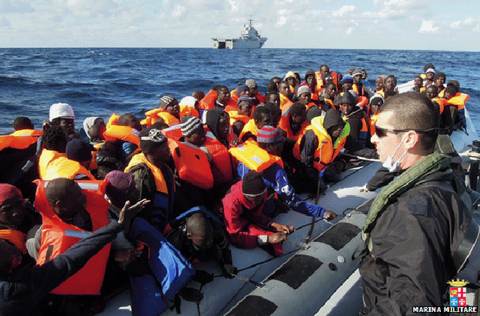 The migrants were later transferred to the amphibious assault ship San Marco (on horizon) for their journey to the Italy