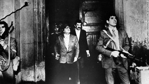 Armed guards watch out for attackers as Allende leaves the Moneda Presidential Palace during the military coup in which he was overthrown and killed