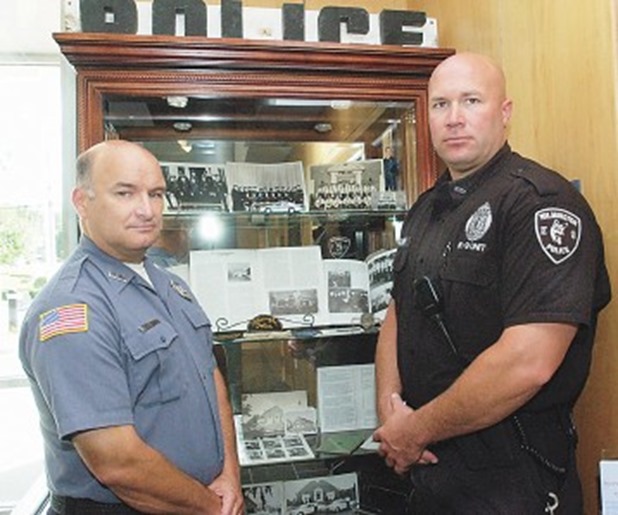 At left, Wilmington police 0fficers Paul Chalifour, left, and Eric Palmer with some of the department’s historical artifacts on display at the police station on Adelaide Street. At right are some old photos, billy clubs and a camera. SUN PHOTOS/BOB WHITAKER