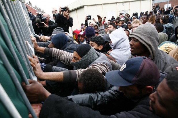 Basketball Americans at Calais attempt to push down a barricade keeping them out of the UK. Having refused high-paying CEO jobs at French corporations, they believe they will better serve humanity working on Britain's space program.