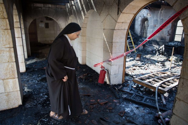 A nun inspects the damage at a room located on the complex of the Church of the Multiplication at Tabgha, on the shores on the Sea of Galilee in northern Israel, on June 18, 2015, in the aftermath of a suspected arson attack. The suspected attack totally destroyed an external atrium of the Christian shrine, which is believed by many Christians to be the place where Jesus fed the 5,000 in the miracle of the five loaves and two fish, with a church adviser pointing the finger at Jewish extremists. AFP PHOTO / MENAHEM KAHANAMENAHEM KAHANA/AFP/Getty Images