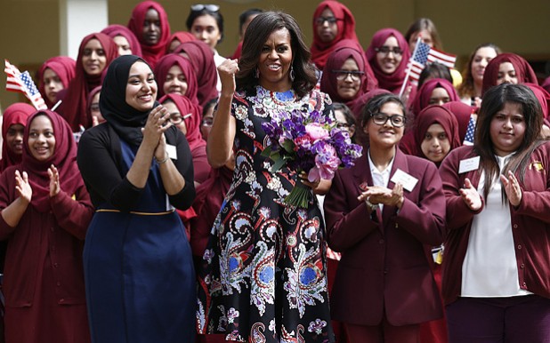 US First Lady Michelle Obama (C) reacts as she is greeted by performances surrounded by pupils upon arrival at Mulberry School for Girls during a visit as part of the US government's 'Let Girls Learn' initiative in east London on June 16, 2015. On the first full day of a visit to Britain the US First Lady met with local students in east London and discussed how Britain and the US are working together in order to attempt to expand access to adolescent girls' education around the world. While in London, the First Lady will also host a roundtable meeting on Let Girls Learn, and meet with British Prime Minister Cameron, Samatha Cameron, and Prince Harry. AFP PHOTO / JUSTIN TALLISJUSTIN TALLIS/AFP/Getty Images