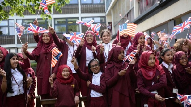 Pupils at the Mulberry School for Girls in Tower Hamlets in east London wave British and American flags ahead of a visit by Michelle Obama