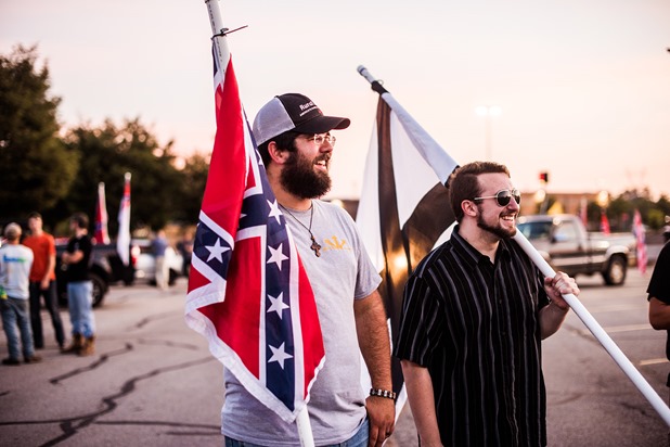 Mathew Heimbach, center talks with a group of supporters during a confederate flag rally that ended in a parking lot in Knoxville, Tennessee after motorcading through the city on Thursday, July 17, 2015. Host Tom Pierce, and guest, Mathew Heimbach delivered speeches at the meeting place in Seymour, Tennessee before prompting the group to drive through the city with flags raised. Mike Belleme for Al Jazeera America 