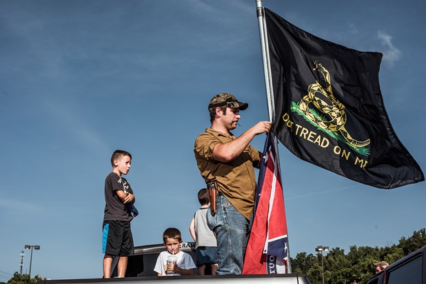 Ira Pierce erects his flags on the back of his truck during a confederate flag rally held in a parking lot in Seymour, Tennessee on Thursday, July 17, 2015. Host Tom Pierce, and guest, Mathew Heimbach delivered speeches before prompting the group to drive with flags raised through Knoxville.  Mike Belleme for Al Jazeera America 