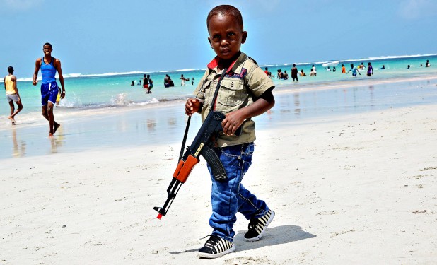 TOPSHOTS A Somali boy walks with a toy g...TOPSHOTS A Somali boy walks with a toy gun along the Lido Beach near Mogadishu on August 8, 2013. Muslims worldwide are celebrating the holiday of Eid Al Fitr which marks the end of Ramadan. AFP PHOTO / Mohamed AbdiwahabMohamed Abdiwahab/AFP/Getty Images