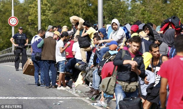 2C6B40CD00000578-3249667-Migrants_and_refugees_line_up_as_they_wait_to_cross_the_border_f-a-111_1443223070501