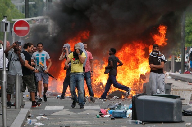 Rioters face riot police, following a pro-Palestinian demonstration, in Sarcelles, north of Paris, Sunday, July 20, 2014.  French youth defying a ban on a protest against Israels Gaza offensive went on a rampage in a Paris suburb, setting fire to cars and garbage cans after a peaceful demonstration. (AP Photo/Thibault Camus)