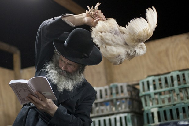 An Ultra Orthodox Jewish man in the religious neighborhood of  Ashdod participates in a Kaparot ritual in which a chicken is swung over one's head in belief that one transfers the sins from the past year into the chicken. The ritual is performed before the Day of Atonement, Yom Kippur, the holiest day in the Jewish year. The chicken is later slaughtered and given to charity. Photo by Dima Vazinovich / Flash90.