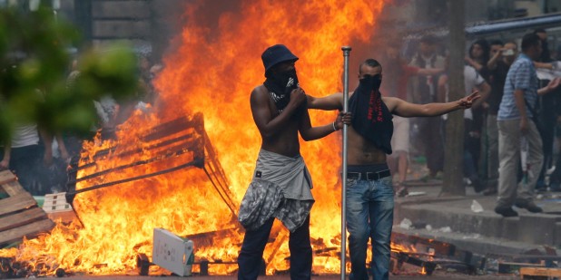 Protesters stand in front of a fire barricade near the aerial metro station of Barbes-Rochechouart, in Paris, on July 19, 2014, during clashes with French riot police in the aftermath of a demonstration, banned by French police, to denounce Israel's military campaign in Gaza and show support to the Palestinian people. Demonstrators threw rocks and bottles at anti-riot squads blocking their route, who responded with tear gas lobbied into the streets. AFP PHOTO / FRANCOIS GUILLOT        (Photo credit should read FRANCOIS GUILLOT/AFP/Getty Images)