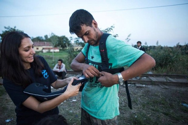 IsraAID worker Rachel Lasry Zahavi (left) giving an Afghan invader her “Baby Bjorn” sling.