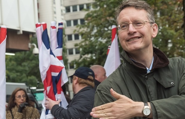 A BNP spekaer makes a 'Queneele', a racist gesture, at the BNP 'No More Immigration' protest outside Lunar House, the UK Visas and Immigration HQ in Croydon.