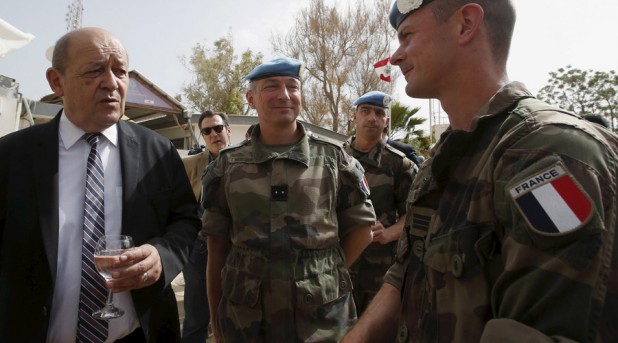 French Defense Minister Jean-Yves Le Drian (L) chats with French peacekeepers of the United Nations Interim Force in Lebanon (UNIFIL) during his visit to their base in Deir Kifa village, southern Lebanon April 20, 2015. The first shipment of French weapons and military equipment arrived in Lebanon on Monday under a Saudi-funded deal worth $3 billion to bolster the Lebanese army's fight against militants encroaching from neighboring Syria. REUTERS/Ali Hashisho - RTX19IOL