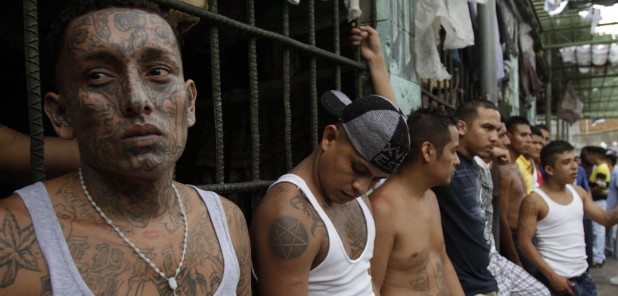 In this July 22, 2012 photo, inmates belonging to the M-18 gang stand inside the prison in Quezaltepeque , El Salvador. Six months after El Salvador brokered an historic truce between two rival gangs to curb the nation's daunting homicide rate, officials are split over whether the truce actually works. The gangs, which also operate in Guatemala and Honduras, are seeking truce talks in those countries as well. (AP Photo/Luis Romero)