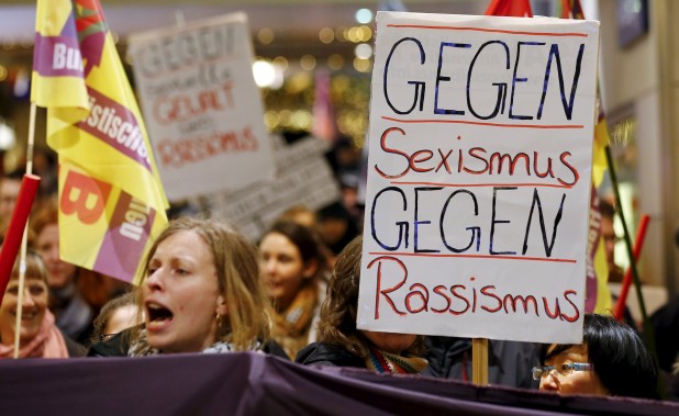 Women shout slogans and hold up a placard that reads "Against Sexism - Against Racism" as they march through the main railways station of Cologne, Germany, January 5, 2016. About 90 women have reported being robbed, threatened or sexually molested at the New Year's celebrations outside Cologne's cathedral by young, mostly drunk, men, police said on Tuesday.   REUTERS/Wolfgang Rattay