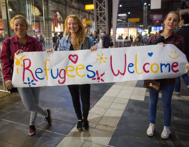 Girls-standing-with-sign-welcoming-migrants-7 0132
