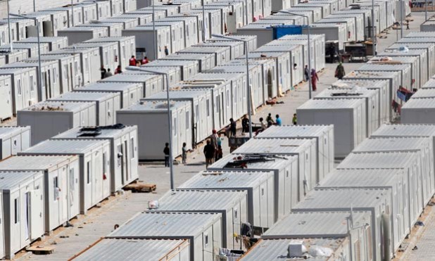 People walk between containers in the refugee camp in Kilis, Turkey