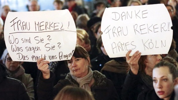 Women hold up placards that read "Mrs. Merkel: Where are you? What are you saying? This worries us!" and "Thanks (Cologne mayor Henriette) Reker!! Poor Cologne"