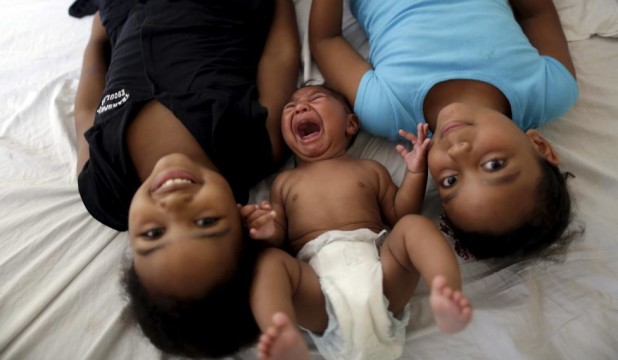 Maria Clara (L) and Camile Vitoria pose for picture with their brother Matheus, who has microcephaly, in Recife, Brazil, January 27, 2016. REUTERS/Ueslei Marcelino