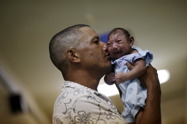 Geovane Silva holds his son Gustavo Henrique, who has microcephaly, at the Oswaldo Cruz Hospital in Recife, Brazil, January 26, 2016. In studies of the current outbreak in Brazil, genetic material from the Zika virus has been identified in studies of brain tissue, placenta and amniotic fluid from several infants with microcephaly and from miscarried fetuses from women infected with the virus. REUTERS/Ueslei Marcelino