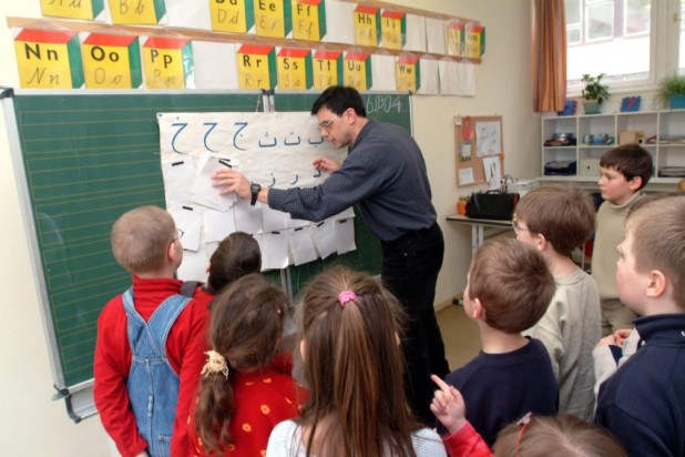Dresden/Sachsen: Im Arabisch-Unterricht an der Kreativitätsschule erklärt der syrische Lehrer Salaheddin Farra den Kindern der Klasse 1 a das Alphabet. Worte und kurze Dialoge haben die Schüler schon in der neuen Fremdsprache gelernt.
