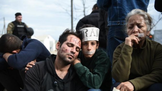 Exhausted migrants sit in no-man's land demanding to be allowed to pass the Greek-Macedonian border near the northern Greek village of Idomeni, Tuesday, Nov. 24, 2015. Several European countries, including EU members Slovenia and Croatia and non-members Serbia and Macedonia, have declared they will only allow "war-zone refugees" from Afghanistan, Iraq and Syria to transit through their countries on their way to central and northern Europe. (AP Photo/Giannis Papanikos)