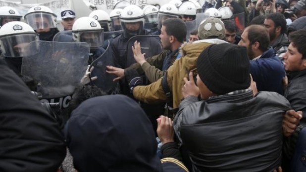 Migrants scuffle with police during a protest demanding the opening of the border between Greece and Macedonia in the northern Greek border station of Idomeni, Greece, Sunday, March 27, 2016. A split appears to have developed among the groups of migrants at the Idomeni border encampment, with Greek riot police who, so far, have used only their shields to protect the border. (AP Photo/Darko Vojinovic)