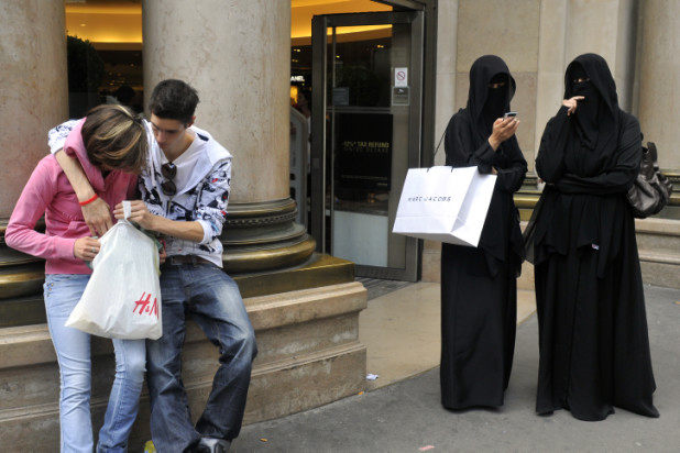 **File** France . Paris . August 03, 2009 . Muslim women stand next to a couple, all four with shopping bags from Clothes Stores, in the center of the city. Serge Attal / Flash 90 *** Local Caption *** öøôú ðùéí öøôúéåú îåñìîéåú àéñìí ùçåø ðéâåã æåâ áéçã áâãéí çðåú ÷ðéåú