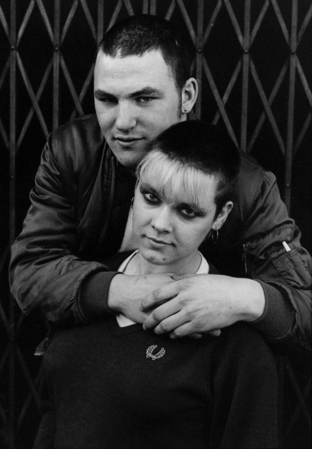 Skinhead couple, man with his arms round womans shoulder