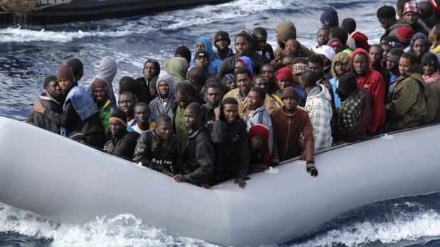 Migrants sit in a boat during a rescue operation by the Italian navy off the coast of Sicily on Nov. 28. Italy is looking to revamp the way it handles the hundreds of thousands of migrants who arrive annually.