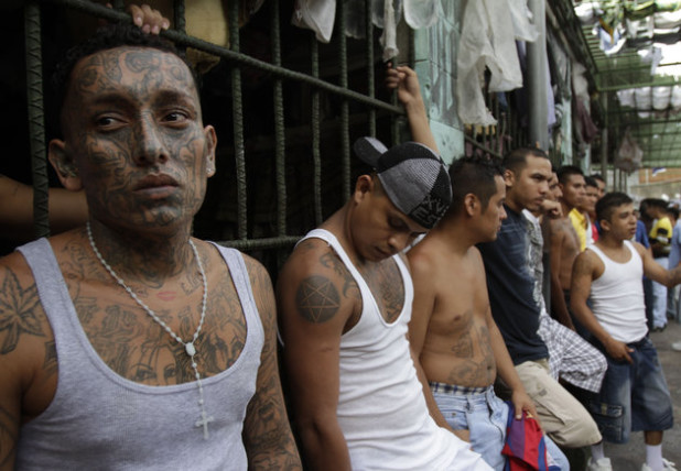 In this July 22, 2012 photo, inmates belonging to the M-18 gang stand inside the prison in Quezaltepeque , El Salvador. Six months after El Salvador brokered an historic truce between two rival gangs to curb the nation's daunting homicide rate, officials are split over whether the truce actually works. The gangs, which also operate in Guatemala and Honduras, are seeking truce talks in those countries as well. (AP Photo/Luis Romero)