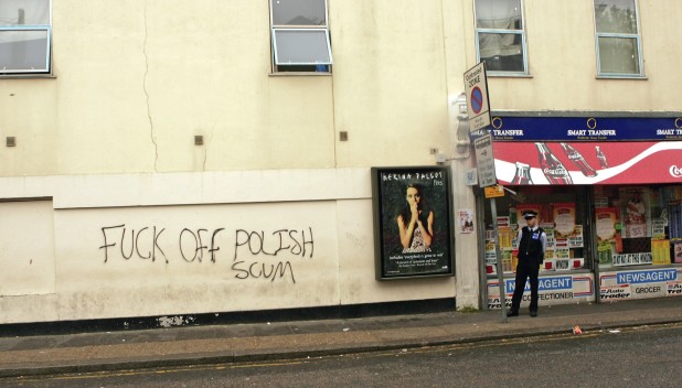 LONDON - MAY 15:  (EDITOR'S NOTE: PROFANITY)  A British police officer stands near a wall after anti-Polish graffti was sprayed on it in an area popular with Polish people on May 15, 2006 in west London, England. Following admittance to the European Union in 2004, it is estimated that more than 350,000 Polish immigrants have come to Great Britain, making it the largest wave of immigration for at least 300 years. Most come in search of work as Poland has nearly 20 per cent unemployment.  (Photo by Scott Barbour/Getty Images)