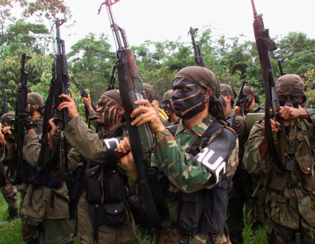 Colombian paramilitaries brandish their automatic assault weapons during a training session in the Colombian jungle in this file photo taken on May 4, 2000. Led by an articulate former army scout, Carlos Castano, the paramilitaries, known as the United Self-Defense Forces of Colombia (AUC), grew ninefold to 8,000 fighters in the eight years to 2000 accused of human rights abuses. The paramilitaries are now one of the biggest military problems for Colombia's guerrilla groups, which are fighting the regular armed forces as well. These have recently been bolstered by $1 billion in mainly military U.S. aid for the government's anti-drug "Plan Colombia".     REUTERS/Jose Miguel Gomez/File photo --- Image by © Reuters/CORBIS