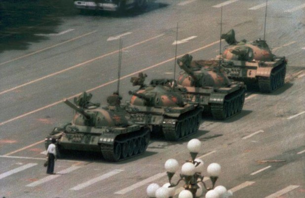 In this June 5, 1989 file photo, a Chinese man stands alone to block a line of tanks heading east on Beijing's Cangan Blvd. in Tiananmen Square. The man, calling for an end to the recent violence and bloodshed against pro-democracy demonstrators, was pulled away by bystanders, and the tanks continued on their way.   (AP Photo/Jeff Widener, File)