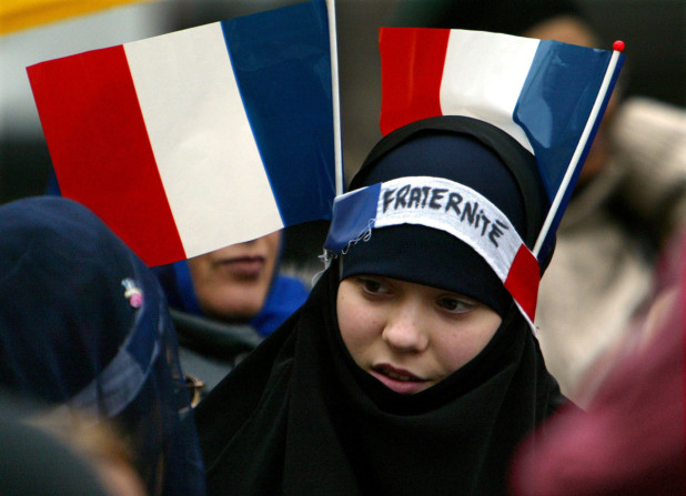 0 A young Muslim girl has two French flags and a headband which reads "Fraternity" on her headscarf as she march among about 3,000 Sikhs from across Europe protesting on a Paris boulevard to defend their traditional headgear against a looming French ban on religious symbols in state schools, January 31, 2004. REUTERS/Charles Platiau