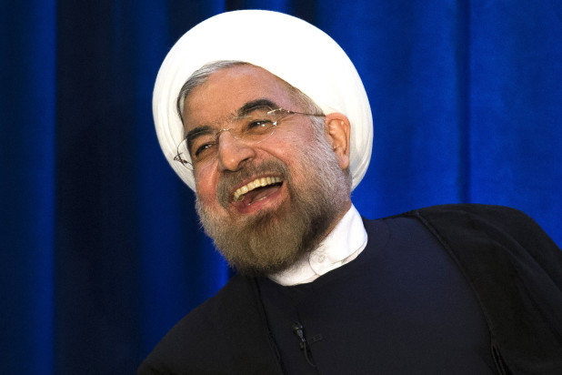 Iranian President Hassan Rouhani laughs during a address and discussion hosted by the Asia Society and the Council on Foreign Relations at the Hilton Hotel in midtown Manhattan, Thursday, Sept. 26, 2013, in New York. (AP Photo/John Minchillo)