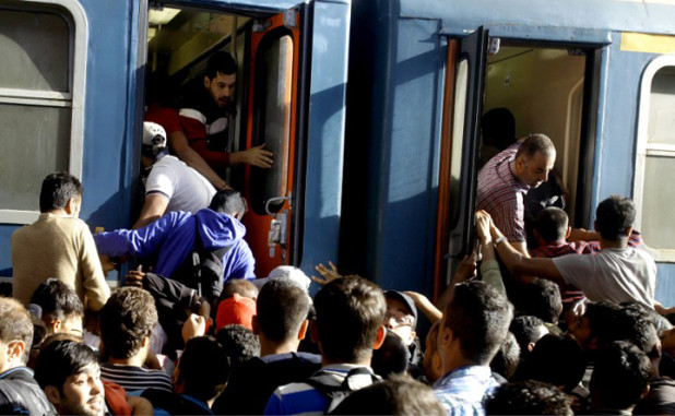 Migrants board into a local train heading to the Hungarian-Austrian border at the main train station in Budapest on September 3, 2015, after authorities re-opened the station to refugees. On the day before Hungarian authorities stopped migrants taking trains to Austria and Germany. AFP PHOTO / PETER KOHALMI