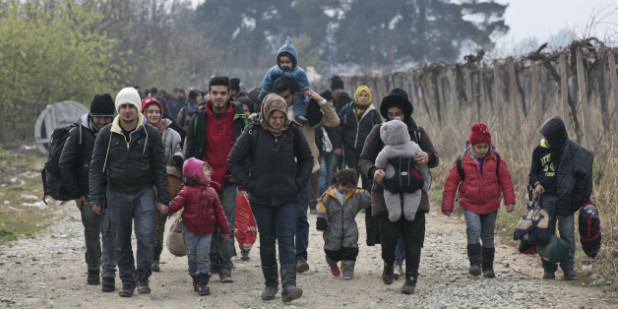 CORRECTS MONTH IN DATE Migrants and refugees walk towards a registration camp after entering Macedonia from Greece, near the southern Macedonian town of Gevgelija, Friday, Dec. 4, 2015. Greek riot police struggled to maintain order on Friday after clashes between asylum-seekers at the country's border with Macedonia. Macedonia is allowing only people from Afghanistan, Iraq and Syria to cross the border, and groups of people from other nationalities have set up makeshift roadblocks, preventing anyone from crossing. (AP Photo/Visar Kryeziu)