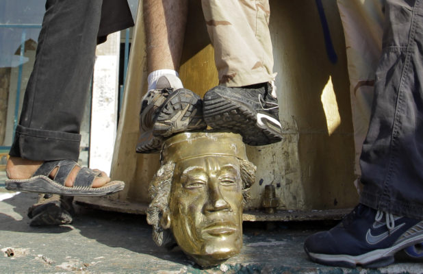 Rebel fighters trample on a head of Moammar Gadhafi inside the main compound in Bab al-Aziziya in Tripoli, LIbya, Tuesday, Aug. 23, 2011. Libyan rebels stormed Moammar Gadhafi's main military compound in Tripoli Tuesday after fierce fighting with forces loyal to his regime that rocked the capital as the longtime leader refused to surrender despite the stunning advances by opposition forces. (AP Photo/Sergey Ponomarev)