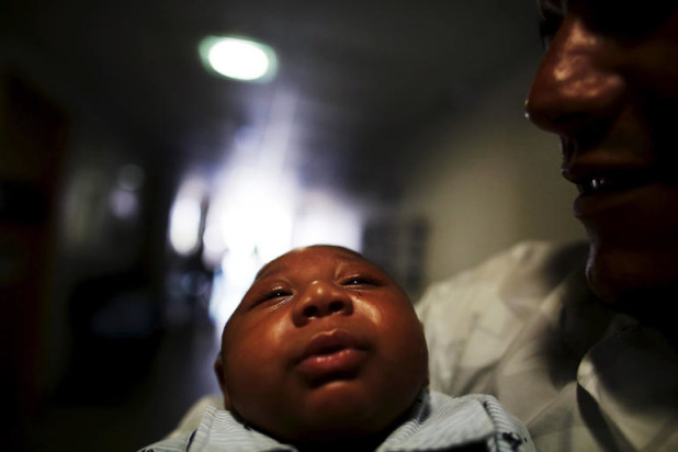 Geovane, holds his son Gustavo Henrique who is 2-months old and born with microcephaly, as they wait for a session with a physiotherapist at the Altino Ventura rehabilitation center in Recife