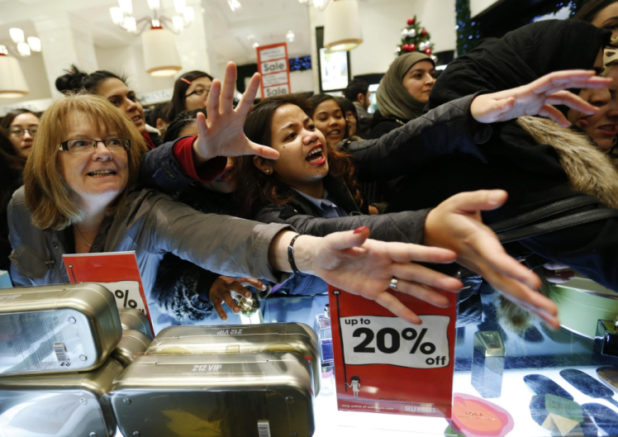 Shoppers beg sales assistants for perfume products in Selfridges on the morning of the Boxing Day sales in London December 26, 2012. Retailers in recent years have started sales online on Christmas Day, ahead of the clearances in stores from Boxing Day, but are increasingly launching their online offers before Christmas after delivery deadlines for the day have passed. REUTERS/Olivia Harris (BRITAIN - Tags: BUSINESS)