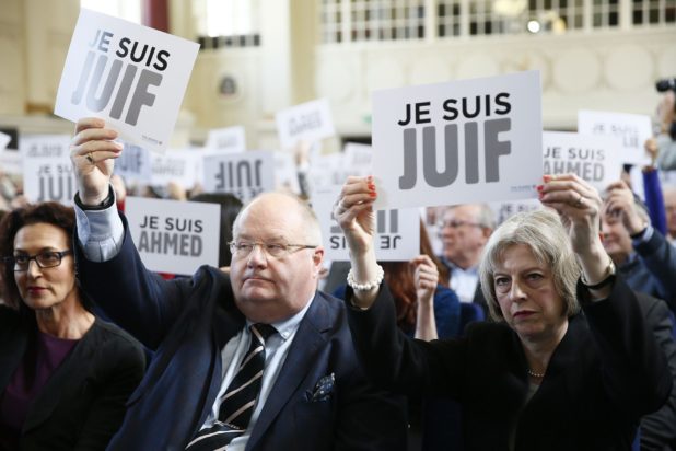 Britain's Secretary of State for Communities Eric Pickles and Home Secretary Theresa May hold up signs reading "I am Jewish" during a Board of Deputies of British Jews event in London, January 18, 2015. REUTERS/Stefan Wermuth  (BRITAIN - Tags: POLITICS)