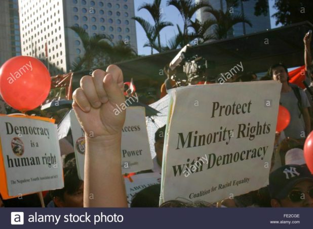 A protester clenches a fist next to a placard reading ''Protect Minority Rights with Democracy'' during a rally in a downtown Hong Kong street, Sunday 13 July 2003, to demand democratic reforms in the territory. The protesters want the Hong Kong legislature to be fully elected and that the chief executive should be elected by the people instead of a Bejing-supported 800-strong committee. EPA PHOTO/EPA/PAUL HILON